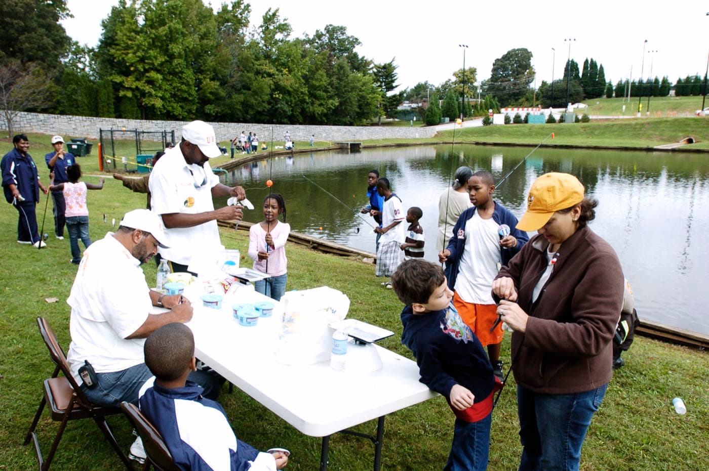 Children gathered at a weigh-in station during a youth fishing derby